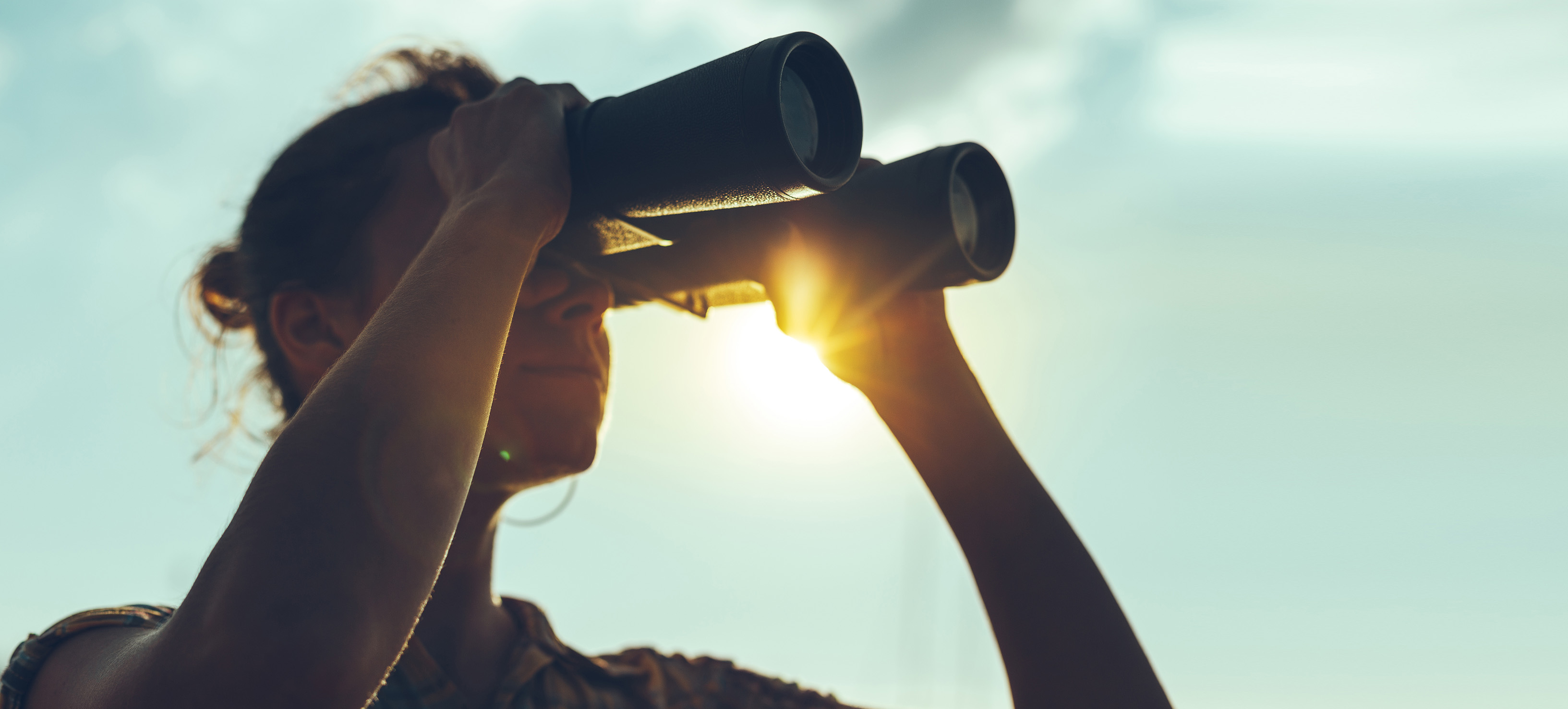 Beautiful Young Woman Looking Through Binoculars At The Sea On A