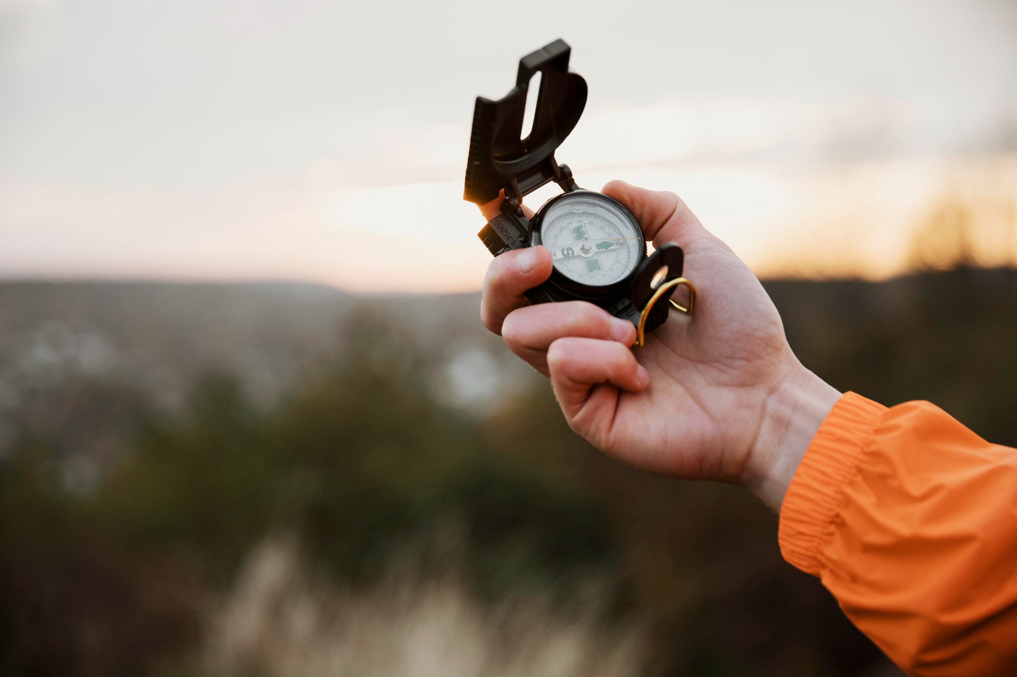man-holding-up-compass-while-road-trip